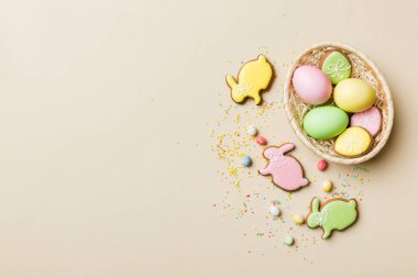 Renkli paskalya kurabiyeleri sepette renkli arka planda çok renkli Paskalya yumurtaları. Pastel renginde Paskalya yumurtası. Kopyalama alanı olan tatil kavramı.