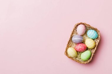 Renkli arka planda dokuma sepetinde çok renkli Paskalya yumurtaları. Pastel renginde Paskalya yumurtası. Kopyalama alanı olan tatil kavramı.