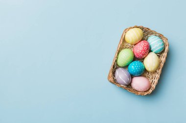 Renkli arka planda dokuma sepetinde çok renkli Paskalya yumurtaları. Pastel renginde Paskalya yumurtası. Kopyalama alanı olan tatil kavramı.