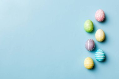 Bayram hazırlığı. Renkli arka planda Paskalya yumurtaları. Pastel renginde Paskalya yumurtası. Kopyalama alanı olan tatil kavramı.