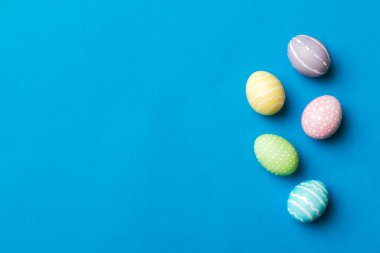 Bayram hazırlığı. Renkli arka planda Paskalya yumurtaları. Pastel renginde Paskalya yumurtası. Kopyalama alanı olan tatil kavramı.