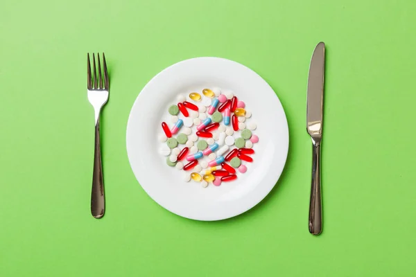 Many different weight loss pills and supplements as food on round plate. Pills served as a healthy meal. Drugs, pharmacy, medicine or medical healthycare concept.