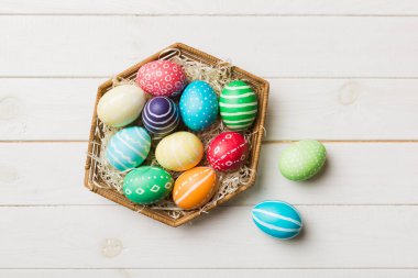 Renkli arka planda dokuma sepetinde çok renkli Paskalya yumurtaları. Pastel renginde Paskalya yumurtası. Kopyalama alanı olan tatil kavramı.