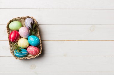 Renkli arka planda dokuma sepetinde çok renkli Paskalya yumurtaları. Pastel renginde Paskalya yumurtası. Kopyalama alanı olan tatil kavramı.