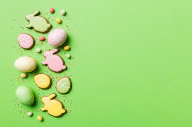 bayram hazırlığı renkli arka planda kurabiyeli çok renkli Paskalya yumurtaları. Pastel renginde Paskalya yumurtası. Kopyalama alanı olan tatil kavramı.