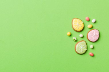 bayram hazırlığı renkli arka planda kurabiyeli çok renkli Paskalya yumurtaları. Pastel renginde Paskalya yumurtası. Kopyalama alanı olan tatil kavramı.
