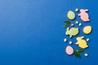 bayram hazırlığı renkli arka planda kurabiyeli çok renkli Paskalya yumurtaları. Pastel renginde Paskalya yumurtası. Kopyalama alanı olan tatil kavramı.