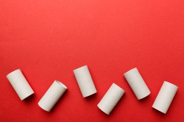 Boş tuvalet kağıdı ruloları ve renk arkaplanı üzerine metin için alanı olan düz bir kompozisyon. Kraft kağıdı veya kartondan yapılmış metal kapaklı geri dönüşümlü kağıt tüp.