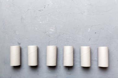 Boş tuvalet kağıdı ruloları ve renk arkaplanı üzerine metin için alanı olan düz bir kompozisyon. Kraft kağıdı veya kartondan yapılmış metal kapaklı geri dönüşümlü kağıt tüp.