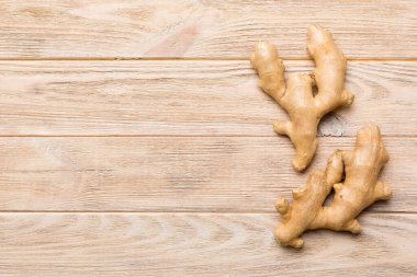 Renkli arka planda yeşil yapraklı kabın içinde zencefil tozu var. Üst görünüm düzlüğü.