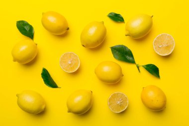 Renkli arka plan olarak pek çok taze limon, üst manzara. Limon ve limon dilimlerinin zarif arka planı Üst görünüm düz yatıyordu.