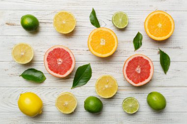 Limon, portakal ve limon gibi açık renkli arka planda limon ağacı yapraklı turunçgil meyveleri. Sağlıklı metin kavramı için alan. Üst görünüm.