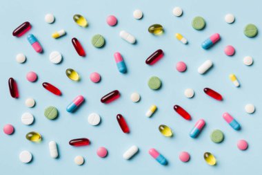 Renkli arka plan ve üst görünüm üzerine yazılmış metinler için birçok farklı hap ve alan. Renkli arka planda farklı haplar, düz yatış.