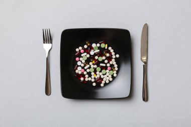 Yuvarlak tabakta yemek olarak birçok farklı kilo kaybı hapı ve takviye maddesi var. Haplar sağlıklı bir yemek olarak sunuldu. Uyuşturucu, eczane, ilaç veya sağlık hizmetleri kavramı.