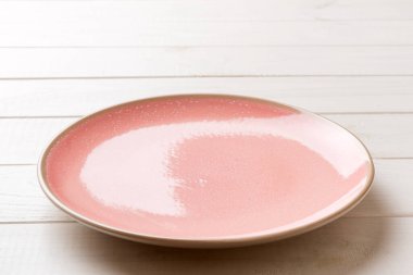 Ahşap arka planda boş pembe plaka manzarası. Tasarımın için boş boşluk.