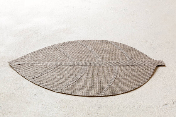 Perspective view of leaf shaped tablecloth for food on cement background. Empty space for your design..