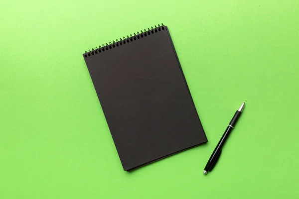 School Notebook Een Gekleurde Achtergrond Spiraalvormige Zwarte Notitieblok Een Tafel — Stockfoto