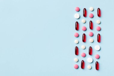 Renkli arka plan ve üst görünüm üzerine yazılmış metinler için birçok farklı hap ve alan. Renkli arka planda farklı haplar, düz yatış.