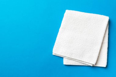 Renkli arkaplanda kopyalama alanı olan beyaz havluların üst görünümü.