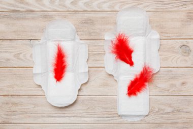 Kadın hijyen ürünleri ya da arka planda kırmızı tüy olan hijyenik ped. Pastel renk. - Yakın çekim. Mesaj için boş bir yer. Kadın günlük hijyeni..