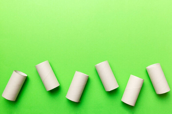 Flat lay composition with empty toilet paper rolls and space for text on color background. Recyclable paper tube with metal plug end made of kraft paper or cardboard.