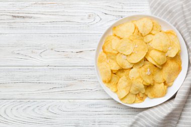 Renkli arka planda izole edilmiş patates cipsi. Lezzetli çıtır patates cipsi kasede. Mesaj için yer var. Üst görünüm.