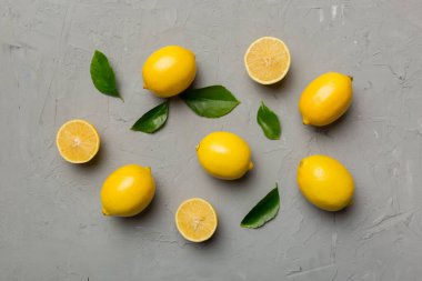 Renkli arka planda yeşil yapraklı taze limonlar, üst görünüm, metin için boşluk.