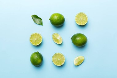 Yeşil yapraklı kireç meyveleri ve beyaz arka planda yarım dilim kesilmiş. Üst Manzara. Kopyalama alanı olan düz.