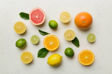 Limon, portakal ve limon gibi açık renkli arka planda limon ağacı yapraklı turunçgil meyveleri. Sağlıklı metin kavramı için alan. Üst görünüm.