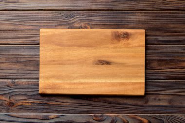 Çimento arka planında ahşap kesim tahtasının üst görüntüsü. Tasarımın için boş boşluk.