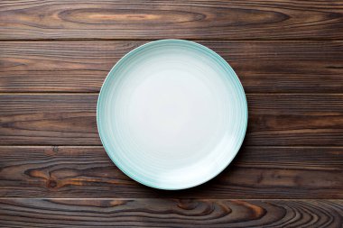 Ahşap zemindeki boş mavi tabağın üst görüntüsü. Tasarımın için boş boşluk.