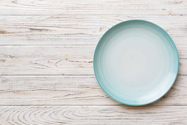 Ahşap zemindeki boş mavi tabağın üst görüntüsü. Tasarımın için boş boşluk.