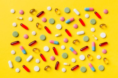 Renkli arka plan ve üst görünüm üzerine yazılmış metinler için birçok farklı hap ve alan. Renkli arka planda farklı haplar, düz yatış.