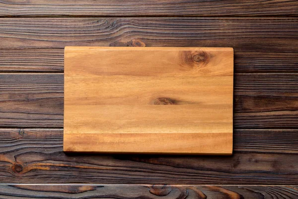 Çimento arka planında ahşap kesim tahtasının üst görüntüsü. Tasarımın için boş boşluk.