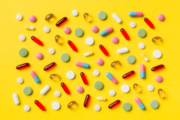 Renkli arka plan ve üst görünüm üzerine yazılmış metinler için birçok farklı hap ve alan. Renkli arka planda farklı haplar, düz yatış.