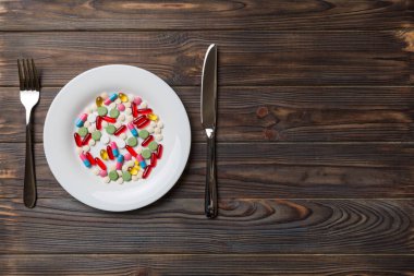 Yuvarlak tabakta yemek olarak birçok farklı kilo kaybı hapı ve takviye maddesi var. Haplar sağlıklı bir yemek olarak sunuldu. Uyuşturucu, eczane, ilaç veya sağlık hizmetleri kavramı.