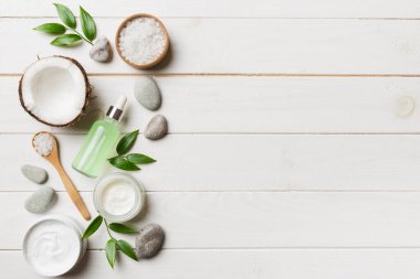 Hindistan cevizi yağı dolu kavanozlar ve renkli arka planda kozmetik kremi. Üst Manzara. Metnin için boş yer. Doğal spa Hindistan cevizi kozmetik ve organik tedavi konsepti Hindistan cevizi spa bileşimi.