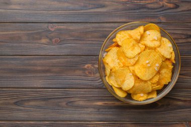 Renkli arka planda izole edilmiş patates cipsi. Lezzetli çıtır patates cipsi kasede. Mesaj için yer var. Üst görünüm.