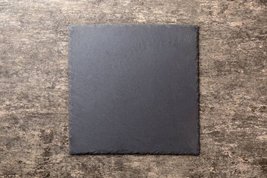 Beton zemin üzerinde boş siyah levha üst görünümü. Tasarımın için boş boşluk.