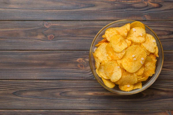 Renkli arka planda izole edilmiş patates cipsi. Lezzetli çıtır patates cipsi kasede. Mesaj için yer var. Üst görünüm.