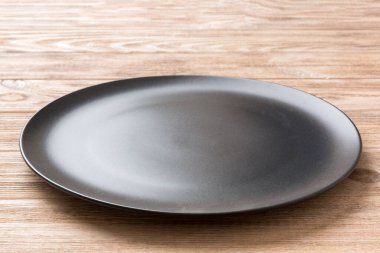 Ahşap zemindeki boş siyah plakanın perspektif görüntüsü. Tasarımın için boş boşluk.