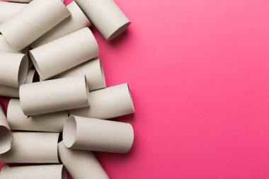 Boş tuvalet kağıdı ruloları ve renk arkaplanı üzerine metin için alanı olan düz bir kompozisyon. Kraft kağıdı veya kartondan yapılmış metal kapaklı geri dönüşümlü kağıt tüp.