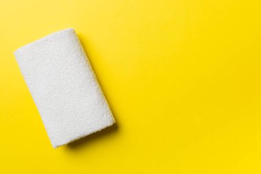 Renkli arkaplanda kopyalama alanı olan beyaz havluların üst görünümü.