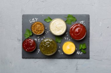 Masada bir sürü farklı sos ve bitki vardı, düz bir manzarası vardı. Tabakta soslar, sağlıklı konsept..