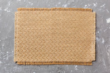 Çimento arka planında yiyecek için kahverengi masa örtüsünün üst görüntüsü. Tasarımın için boş boşluk.