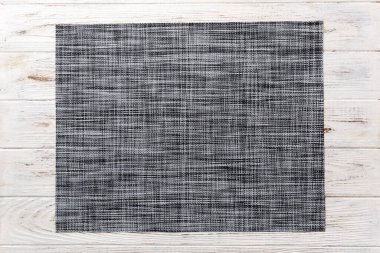 Ahşap arka planda yemek için gri masa örtüsünün üst görüntüsü. Tasarımın için boş boşluk.