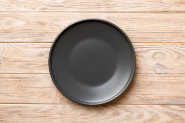 Ahşap arka plandaki siyah plakanın üst görüntüsü. Tasarımın için boş boşluk.