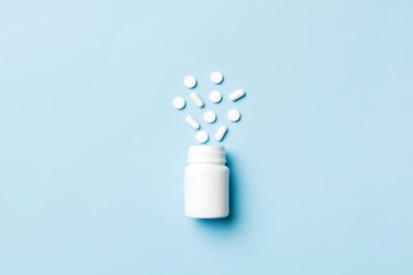 Renkli arka planda plastik şişede çok renkli haplar ve kapsüller, kopyalama alanı. Çeşitli ilaç tabletleri ve haplar, vitamin ve besin takviyeleri kavramı.