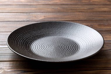 Ahşap zemindeki boş siyah plakanın perspektif görüntüsü. Tasarımın için boş boşluk.