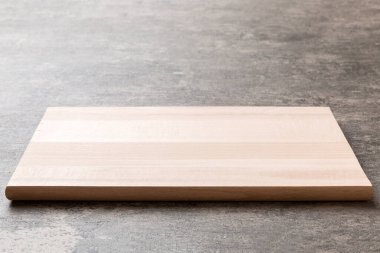 Çimento arka planında tahta kesme tahtası manzarası. Tasarımın için boş boşluk.